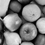 Felipe Peña contemporary art: A black and white photo showing a group of assorted fruits, including a banana, apples, pears, oranges, and kiwis, arranged closely together in a flat lay composition. The textures and shapes of each fruit are clearly visible. , exclusive contemporary art for New York collectors